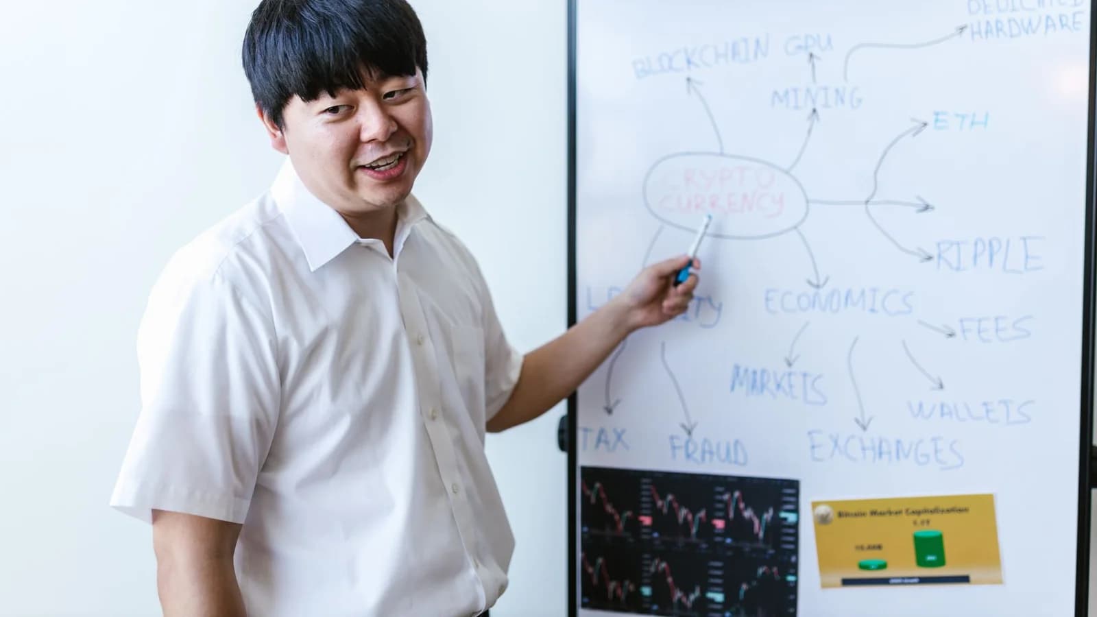 A professional explaining cryptocurrency concepts on a whiteboard during a seminar.