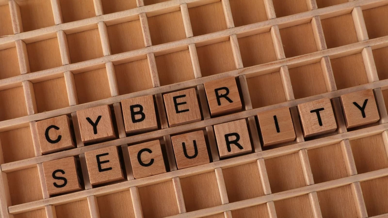 Wooden blocks spelling 'Cyber Security' on a wooden grid background.