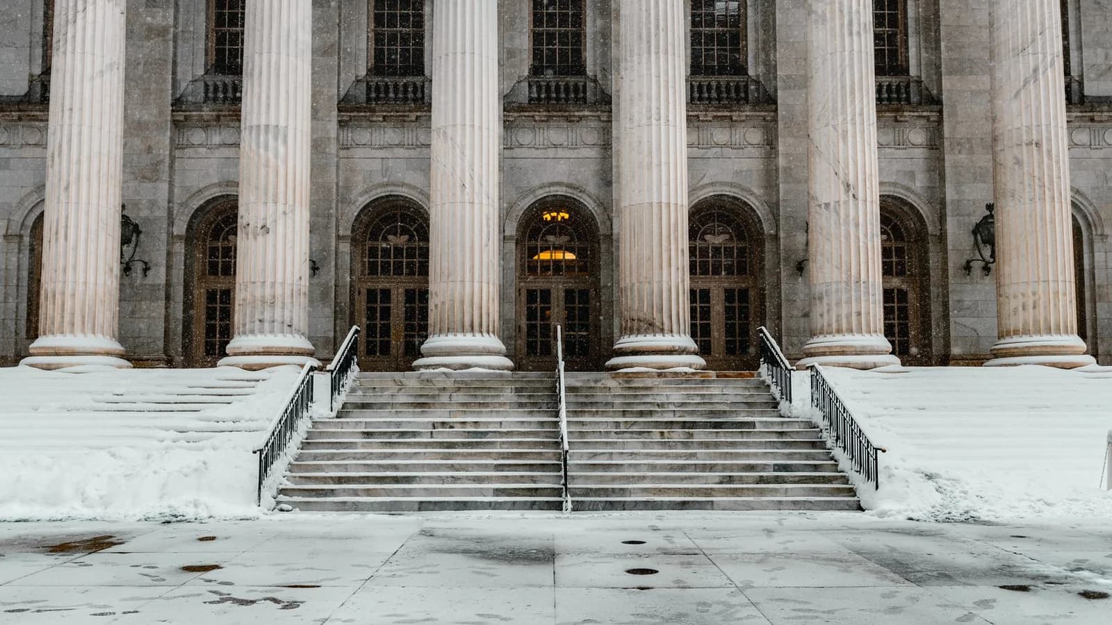Majestic courthouse facade with columns and stairs blanketed in snow, capturing Denver's winter charm.