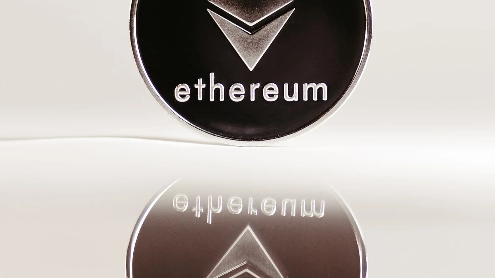 Ethereum coin on a reflective surface
