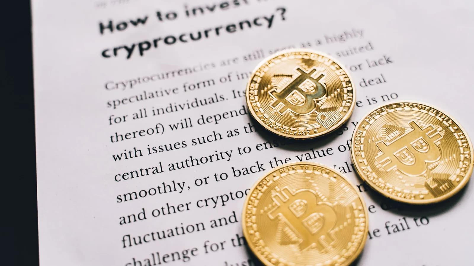 Close-up of Bitcoin coins on an investment guide paper.
