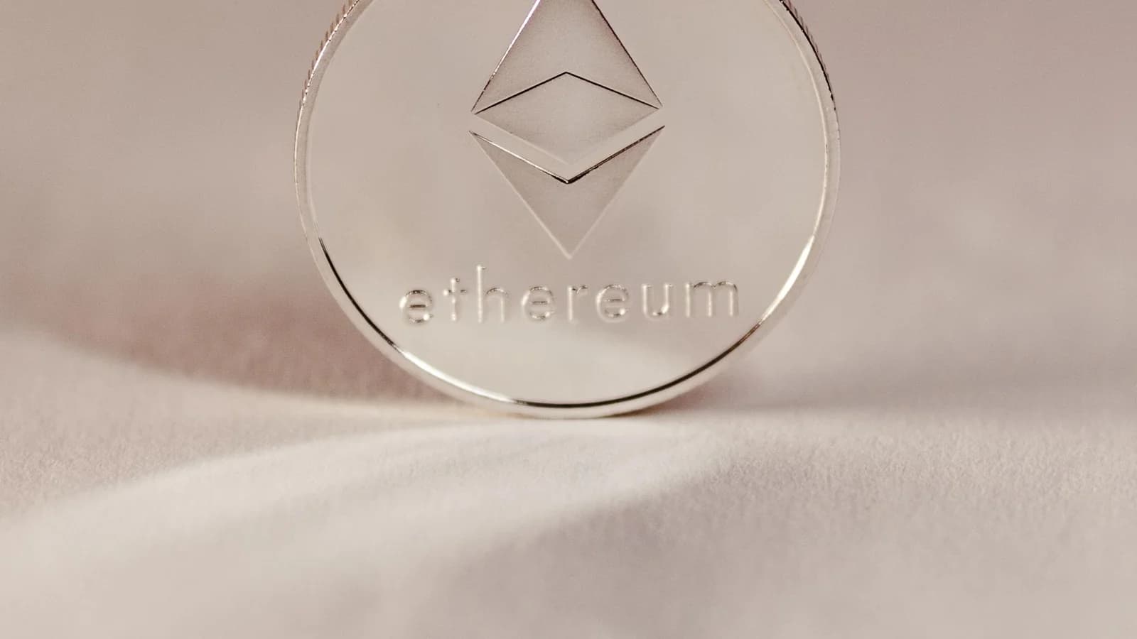 Silver Ethereum coin against a white background